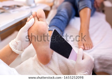 Scrubbing of the sole foot area with foot file, pedicure concept