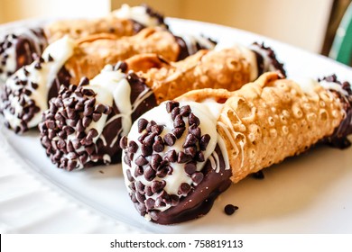 A scrumptious plate of chocolate dipped Cannoli with chocolate chips. A yummy treat for any sweet tooth.