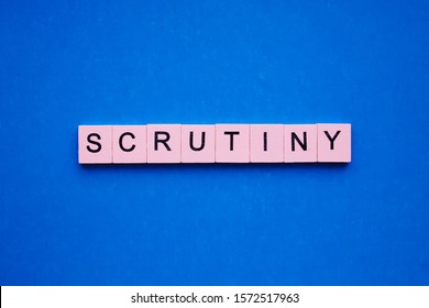 Scrutiny word wooden cubes on blue background - Shutterstock ID 1572517963