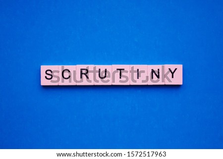 Scrutiny word wooden cubes on blue background