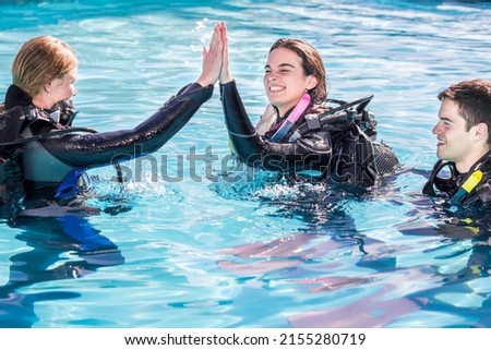 Scuba dive training in the pool with the instructor giving a high five to the happy student