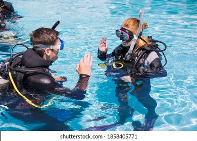 Scuba Dive Training In A Pool Students Showing The Ok Sign Above Water.