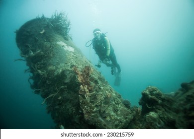 Scuba diver exploring world war II shipwreck in Coron area, Palawan, Philippines.