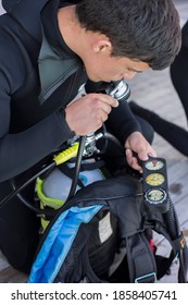 Scuba Diver Kitting Up And Checking His Gear, Testing Regulator And Pressure Gauge Close Up