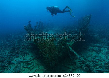 Scuba diver swim over very old ship wreck
