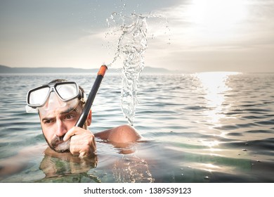 Scuba Diver Swimming In The Sea, Blowing Water Through Snorkel, Splash Of Water Droplets Coming Out Of The Air Tube, Wearing Diving Goggles, Summer Holiday Fun And Joy Concept 