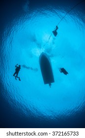Scuba divers descend from a small boat in the Caribbean Sea.