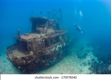 SCUBA Divers Explore An Underwater Shipwreck