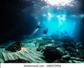 scuba divers exporing underwater caves