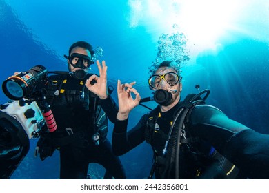 Scuba Divers Swimming in Deep Sea With Sunrays. Young Man DIver Eploring Sea Life. - Powered by Shutterstock