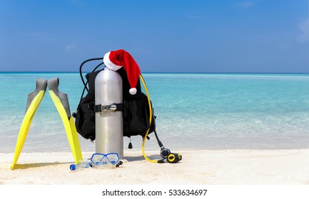 Scuba Diving Equipment With Santa Claus Hat On Tropical Beach