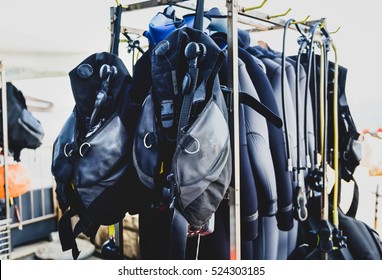 Scuba diving gear ona a stand in diving center. Buoyancy compensators and regulators are ready for beginner or advanced diving course. Drying and washing the diving equipment. - Shutterstock ID 524303185