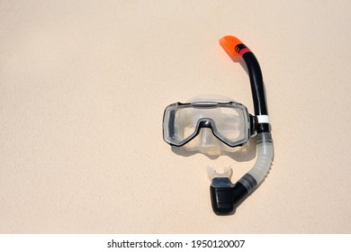 Scuba diving mask with a snorkel on the white sea sand. Diving mask. Photo of a mask and snorkel for swimming in the pool or sea with a central composition on the beach. Scuba diving concept