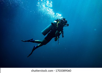 Scuba diving safety stop performed in the deep blue sea - Shutterstock ID 1703389060