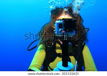 Scuba woman with action camera underwater in the sea 