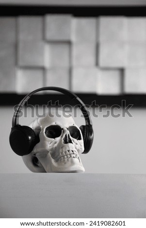 scull in headphones on gray background