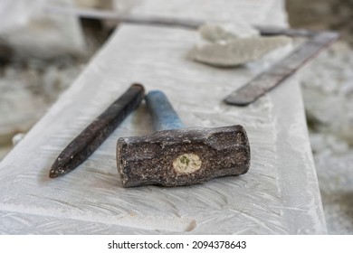 Sculptor tools on a marble slab, close up. Workplace, traditional tools sculptor, red chalk, ruler, hammer and chisel for working stone. Vietnam, Da Nang