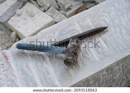 Sculptor tools on a marble slab, close up. Workplace, traditional tools sculptor, red chalk, ruler, hammer and chisel for working stone. Vietnam, Da Nang