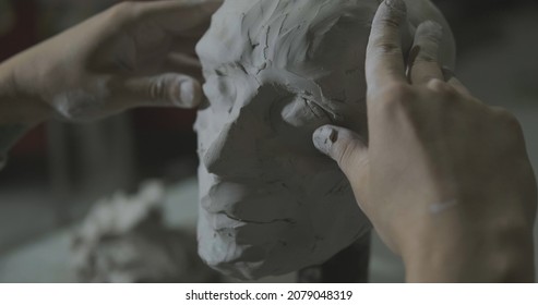Sculptor work with clay portrait of female in dark studio UHD4K