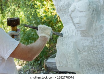 Sculptor at work .stone carving. White marble angel carving.