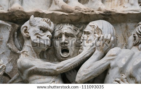 Sculptural group with the image of a devil and sinners on an external facade of the Cathedral, Orvieto, Italy