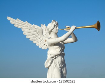 sculpture of an angel blowing golden horn