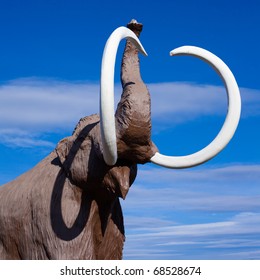 Sculpture Of Extinct Wooly Mammoth In Aggressive Pose.