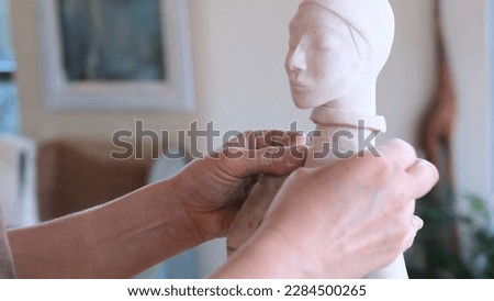 a sculpture girl polishes a limestone statue with sandpaper in a creative art workshop.