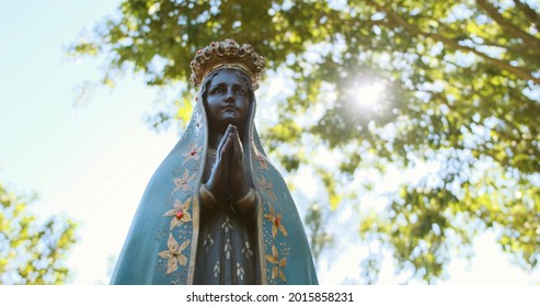 Sculpture of the image of "Nossa Senhora Aparecida" the patroness of Brazil. On nature background on sunny day.