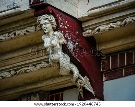 Sculpture of a mermaid decorating an old house