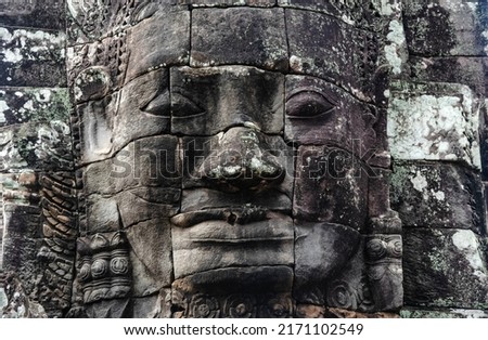 Sculpture of a person's face on sandstone at Bayon Temple in Angkor Thom, Siem Reap, Cambodia.