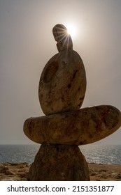 Sculpture symbol made of large pebbles against the blue sky
