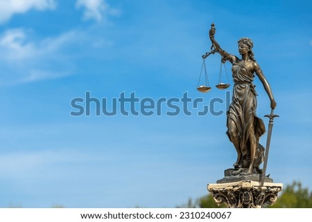 Sculpture of themis, femida or justice goddess on outdoors bright blue sky copy space background