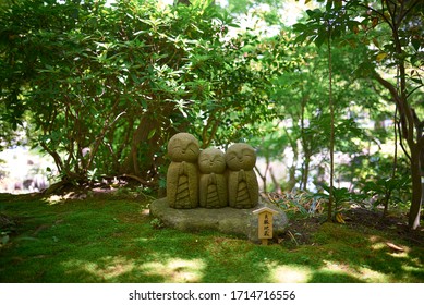 Sculpture Of A Three Smiling Babies In A Japanese Garden