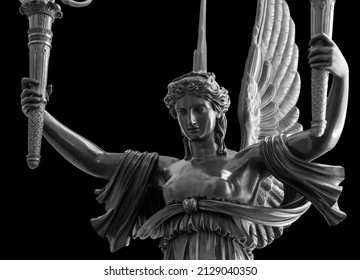 Sculpture of a Winged Victory goddess Nika. Statue of a beautiful holy angel with wings holding a torchs isolated at black background with clipping path