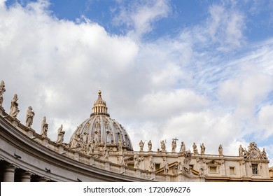 Sculptures of Vatican City and St. Peter's Basilica dome with cloudy blue sky background
