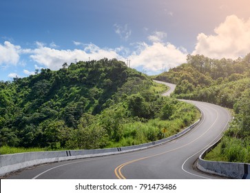 S-curve Road Up To The Hill With Green Tree And Sky At Nan Province Thailand