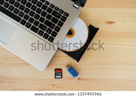 SD Card, Flash Drive USB3.0 and CD DVD Drive Writer Burner Reader of laptop computer on wooden background, Concept of Data storage device