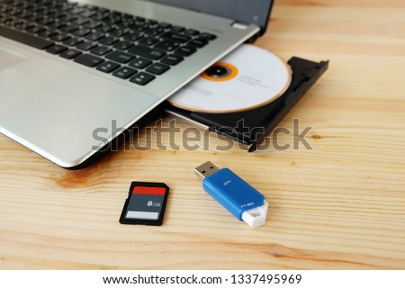 SD Card, Flash Drive USB3.0 and CD DVD Drive Writer Burner Reader of laptop computer on wooden background, Concept of Data storage device