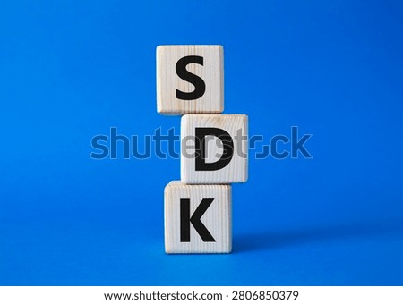 SDK - software development kit. Wooden cubes with word SDK . Beautiful blue background. Business and software development kit concept. Copy space.