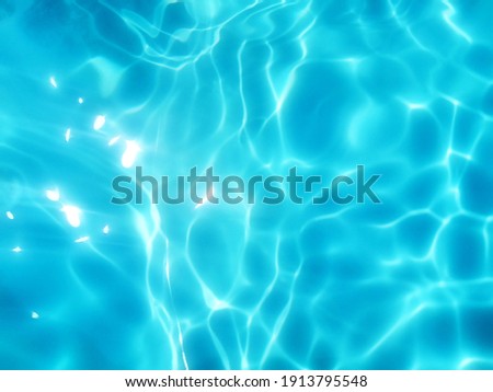 Reflection​ on​ surface​ blue​ water​ in​ the​ sea. Abstract​ of​ surface​ blue​ water​ for​ background. Closeup​ abstract​ of​ surface​ blue​ water. Splash​ed​ water​ in the​ swimming​pool.