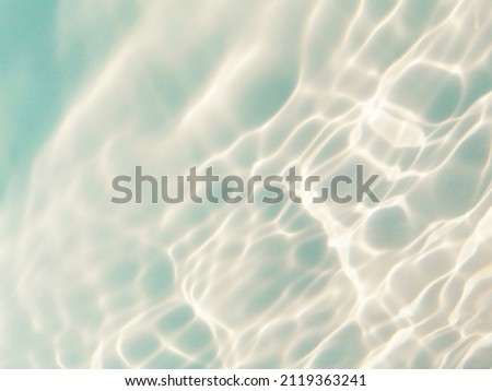 Reflection​ on​ surface​ blue​ water​ in​ the​ sea. Abstract​ of​ surface​ blue​ water​ for​ background. Closeup​ abstract​ of​ surface​ blue​ water. Splash​ed​ water​ in the​ ocean​. Water​ texture.