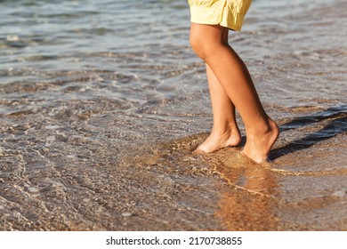 Sea Barefoot Sand Beach Background. Child Legs In Water. Sea Children Holiday .