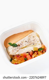 Sea Bass Fillet With Tomato Salad And Sauce In A Plastic Takeout Container