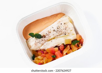 Sea Bass Fillet With Tomato Salad And Sauce In A Plastic Takeout Container