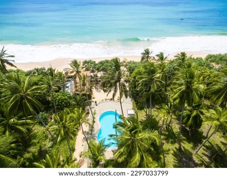 Sea beach, coconut palm trees and hotel pool, Sri Lanka. Aerial view of scenic resort, landscape of seashore with houses in jungle. Travel, vacation, rainforest, ocean and nature concept.