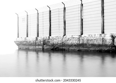 Sea Border. Old Barbed Wire Fence In The Sea. Obstacle, Restriction Of Movement. Illegal Border Crossing.