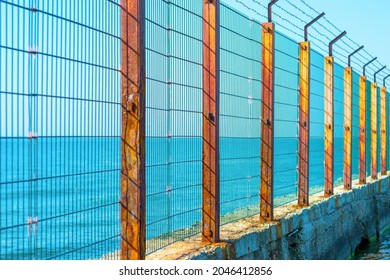 Sea Border. Old Barbed Wire Fence In The Sea. Obstacle, Restriction Of Movement. Illegal Border Crossing.