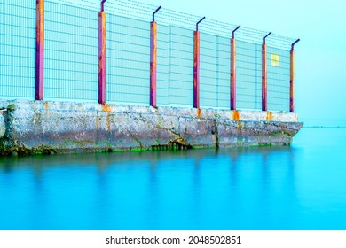 Sea Border. Old Barbed Wire Fence In The Sea. Obstacle, Restriction Of Movement. Illegal Border Crossing.