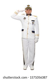 Sea captain in a white suit stands straight and salutes directly to the camera, isolated on a white background.